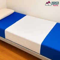 Entremetida impermeable para cama en tejido de rizo blanco con base de PVC, ideal para uso hospitalario y geriátrico